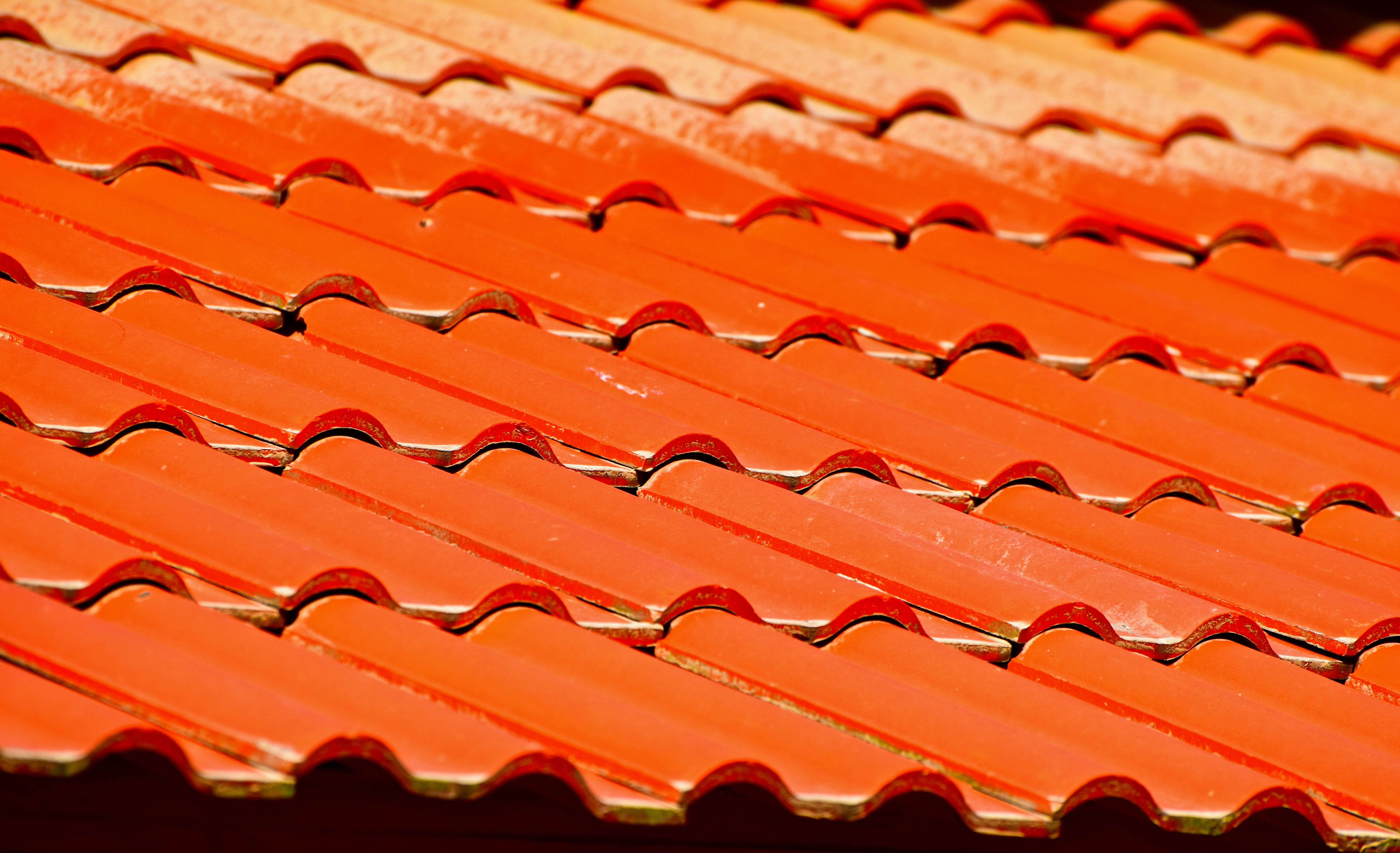Roof of a detached house with a skylight and chimney against the sky